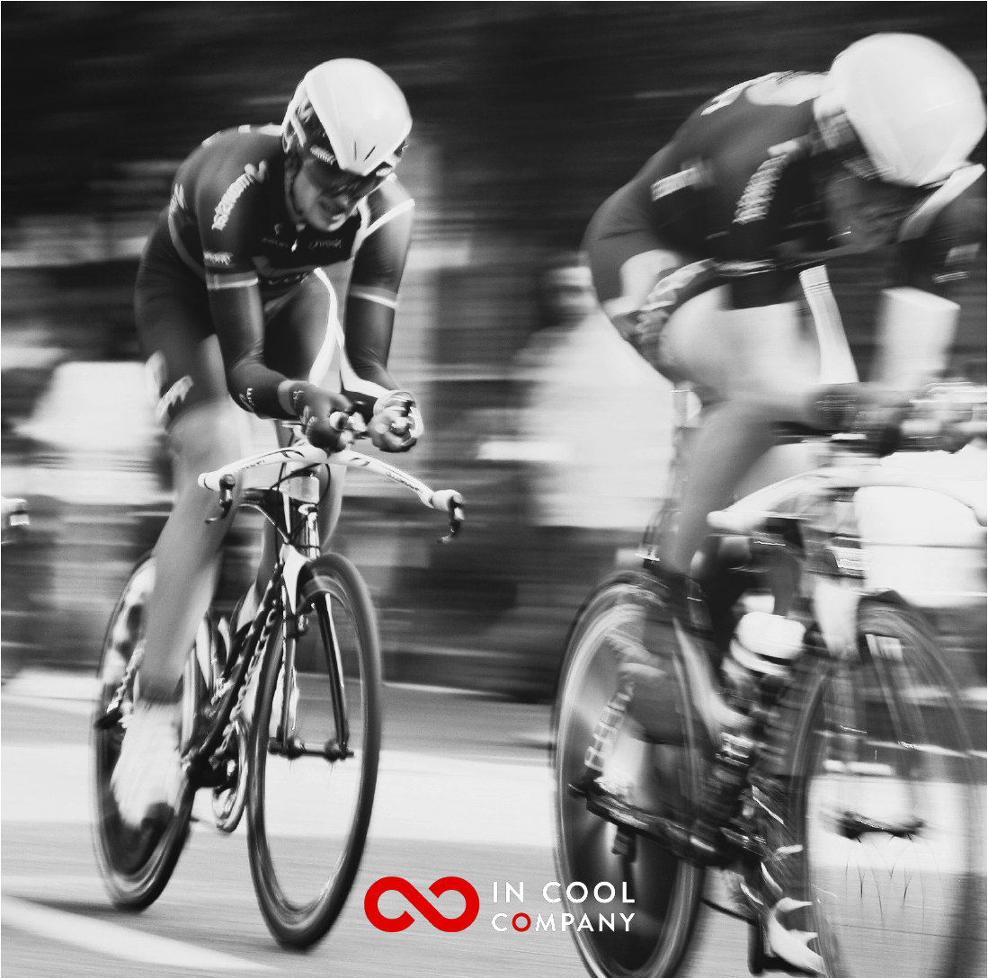 Two professional male cyclists in time trial position racing each other