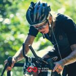 A female with tattooed arms riding her bicycle with intensity