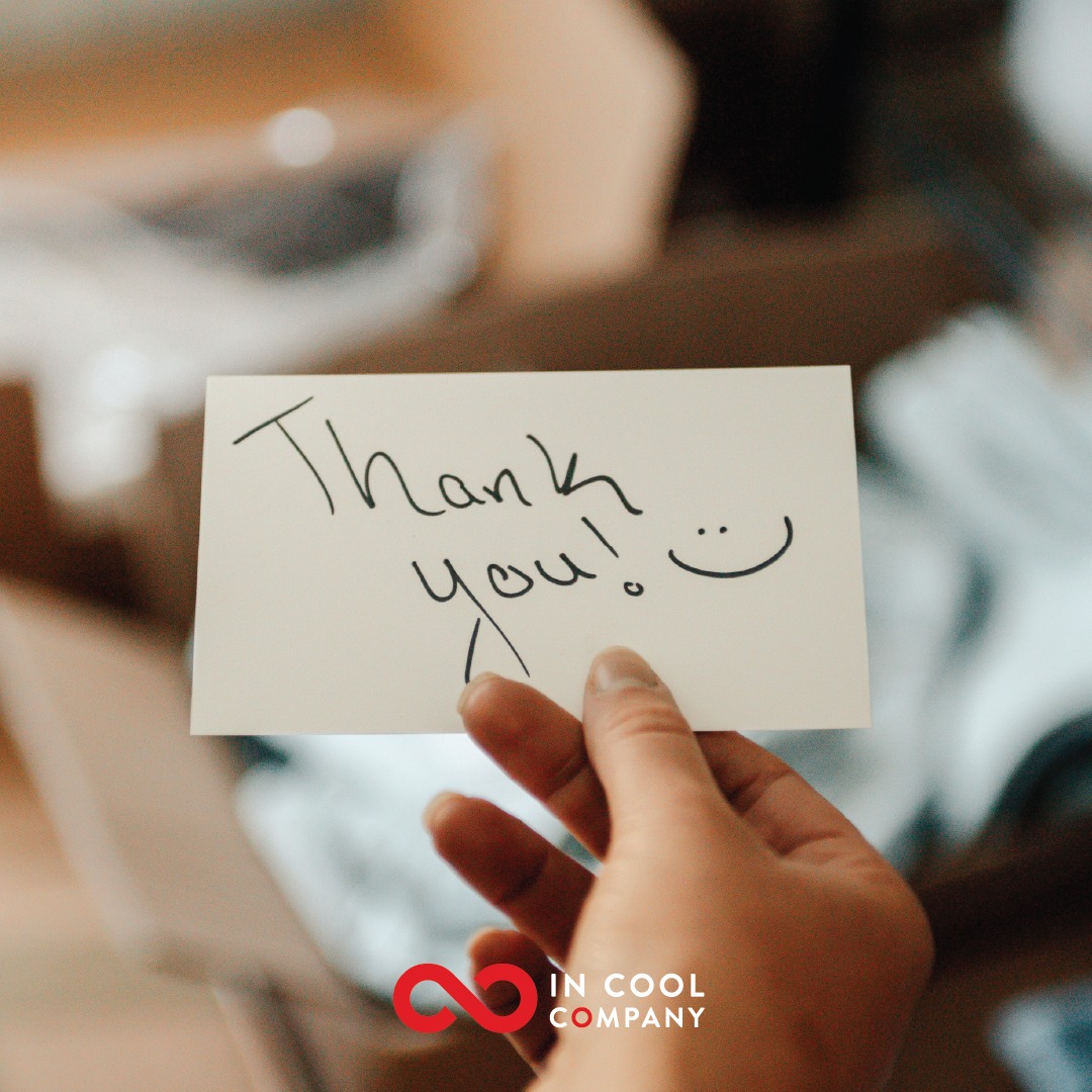 Handwritten thank you note being held out