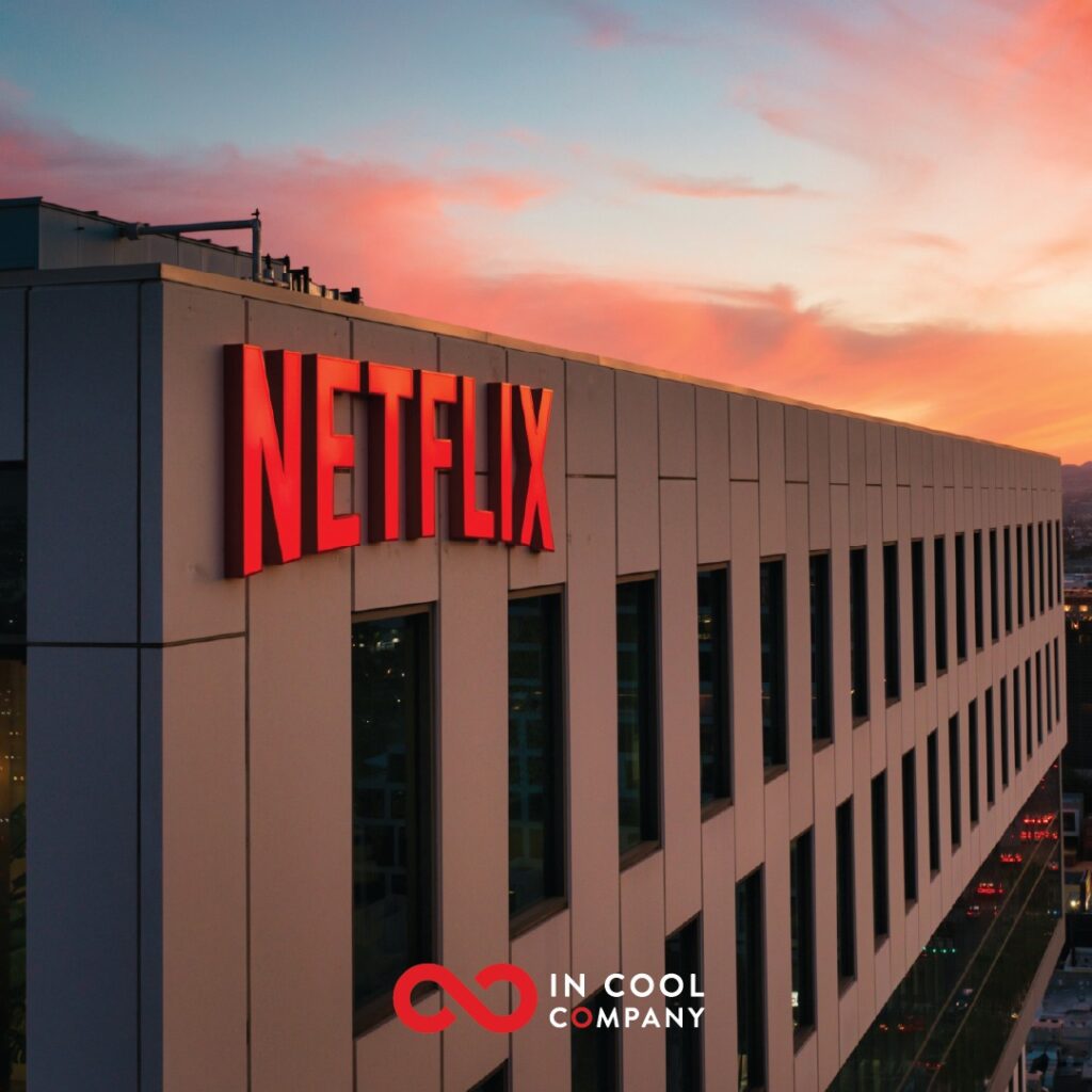 A building with Netflix sign on it and a sunset in the sky beyond