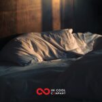 An unmade bed with some morning light shining across it