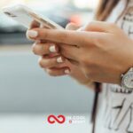 A person uses two hands to hold a mobile phone and look at the screen