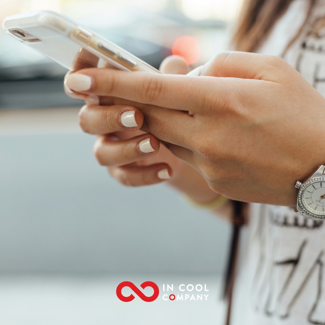 A person uses two hands to hold a mobile phone and look at the screen