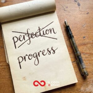 The word perfection is written on a notepad, but it is crossed out and below it is the word progress